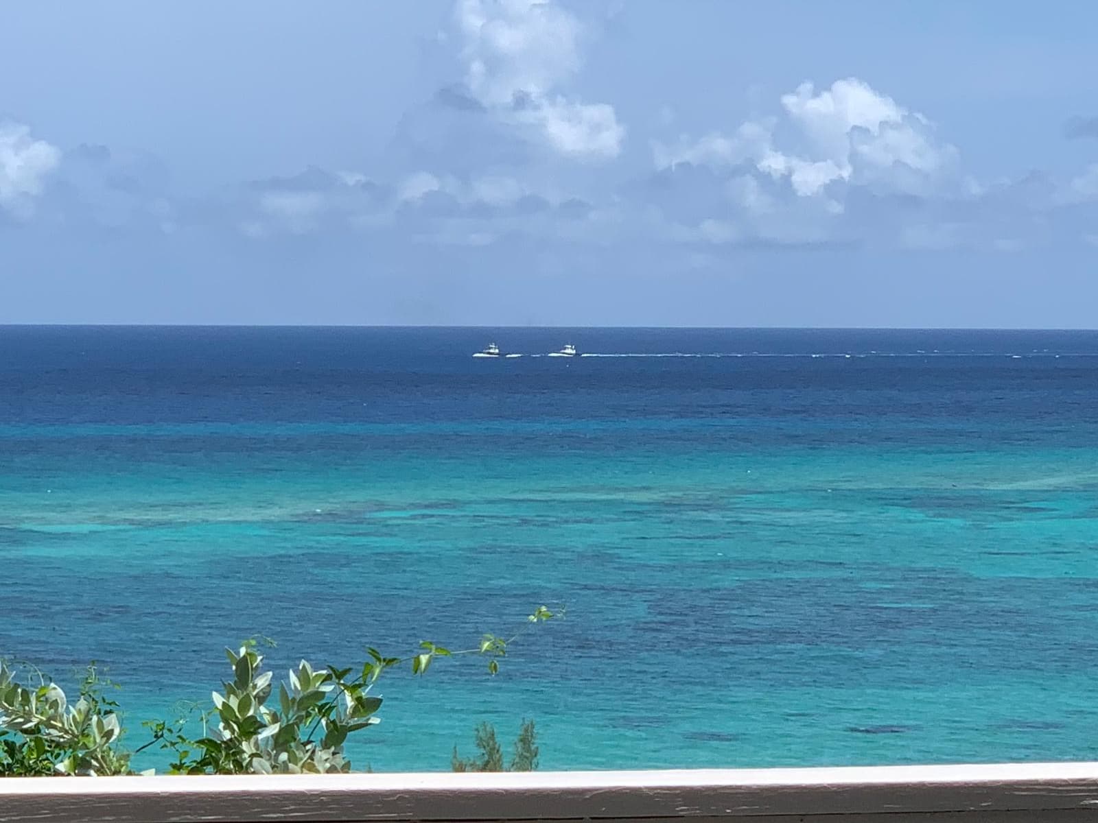 The Atlantic seen from the property, banded pale green and deep blue over the reef, a boat far out